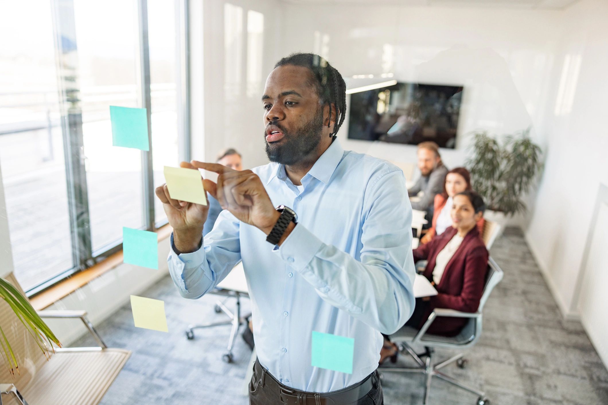 Consultant organizing strategy notes on a glass board
